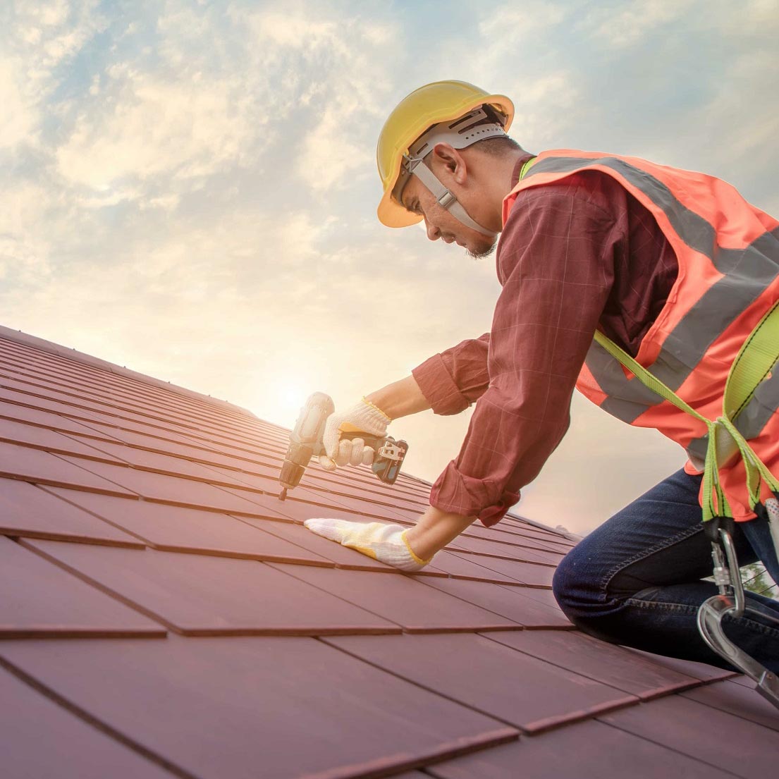Roofer working in special protective work wear gloves, using air